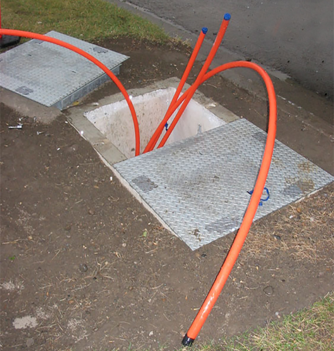 Conduit coming out of manhole in a handhole
